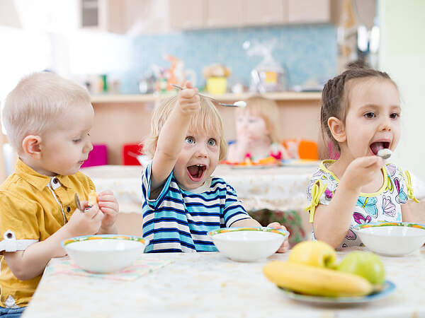 Des enfants mangent à la crèche
