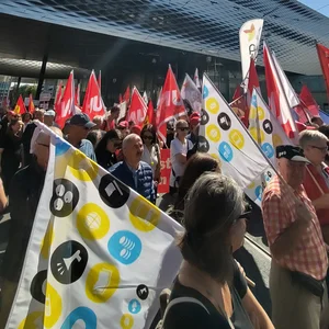 Des syndicalistes portant des drapeaux lors d’une manifestation.
