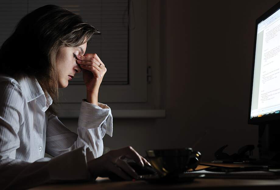 Femme épuisée devant l'ordinateur - après les heures supplémentaires